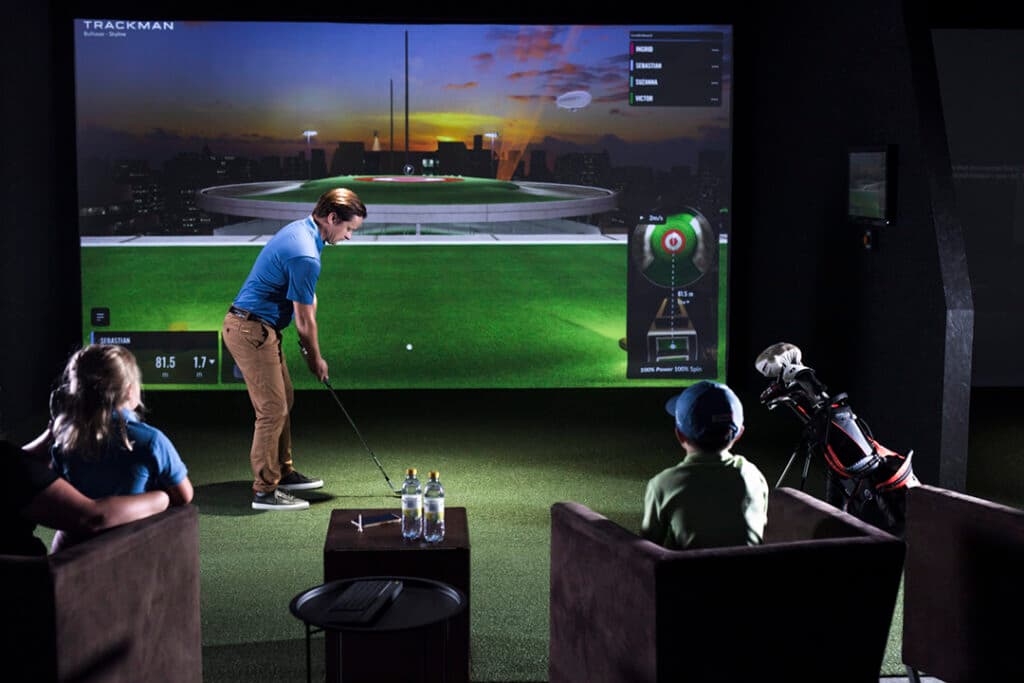 TrackMan iO ceiling-mounted launch monitor in a home golf simulator setup
